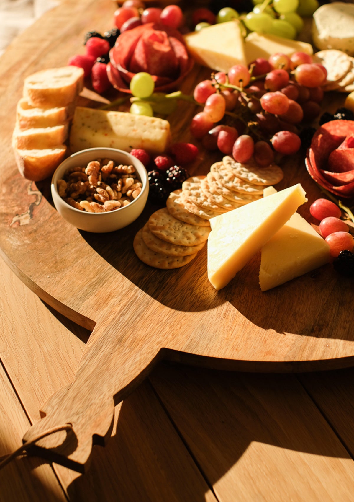 The round Yufka Grazing Board is made from non-porous and durable mango wood.