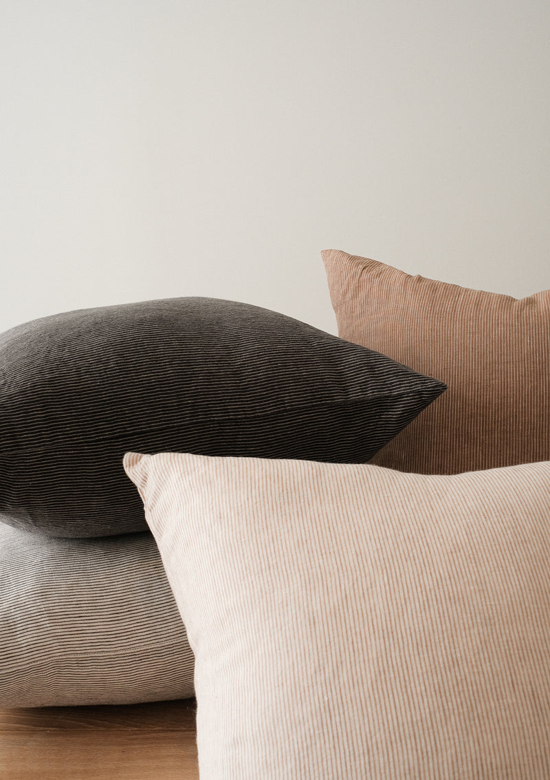 The Adora Pillow cover comes in Sky, Grey, Charcoal, Oat, White with Chocolate,  Walnut, or Chocolate.