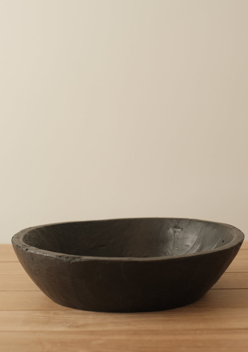 This found wooden bowl has a blackened finish and comes form India.