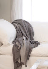 The Enes Cotton Throw is a large throw in reversible charcoal and grey tones. 